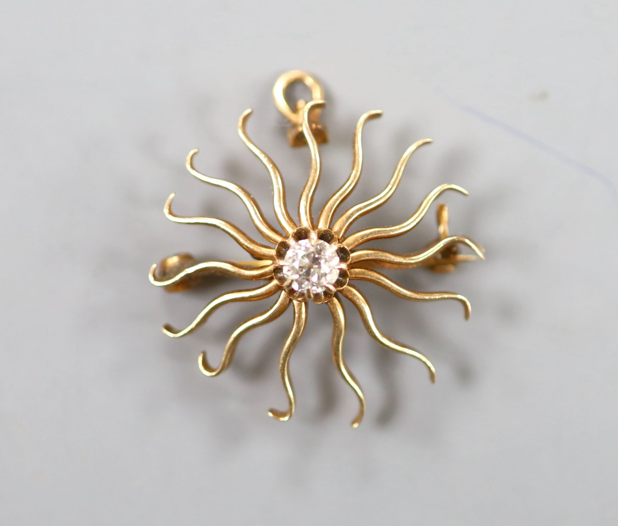 A yellow metal and single stone diamond set sun burst pendant brooch, 25mm, gross weight 4.7 grams